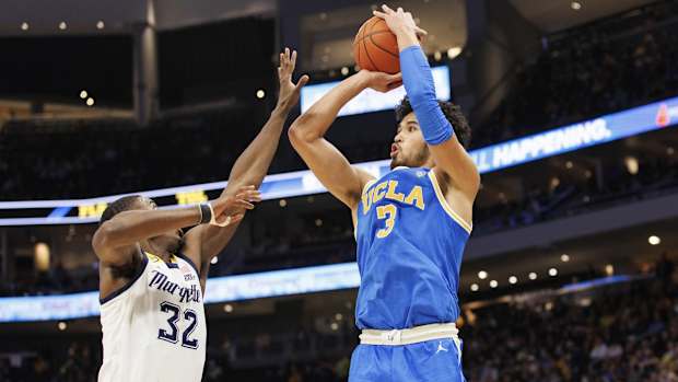 Dec 11, 2021; Milwaukee, Wisconsin, USA; UCLA Bruins guard Johnny Juzang (3) shoots against Marquette Golden Eagles guard Darryl Morsell (32) during the second half at Fiserv Forum. Mandatory Credit: Jeff Hanisch-USA TODAY Sports